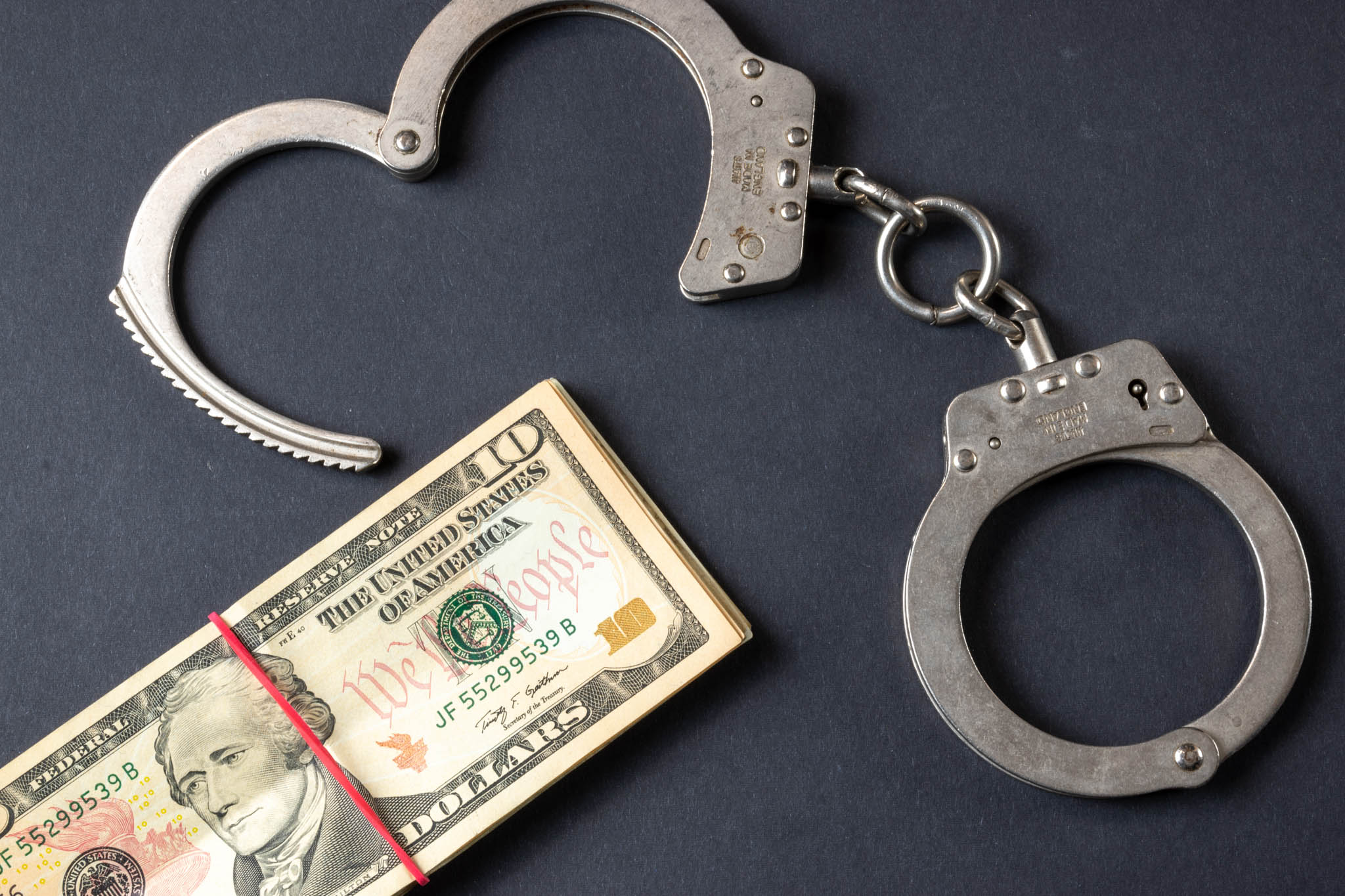 An image of handcuffs and a stack of money - Kevin Peterford, a felony attorney in Palm Beach County, FL, can help with your felony defense.