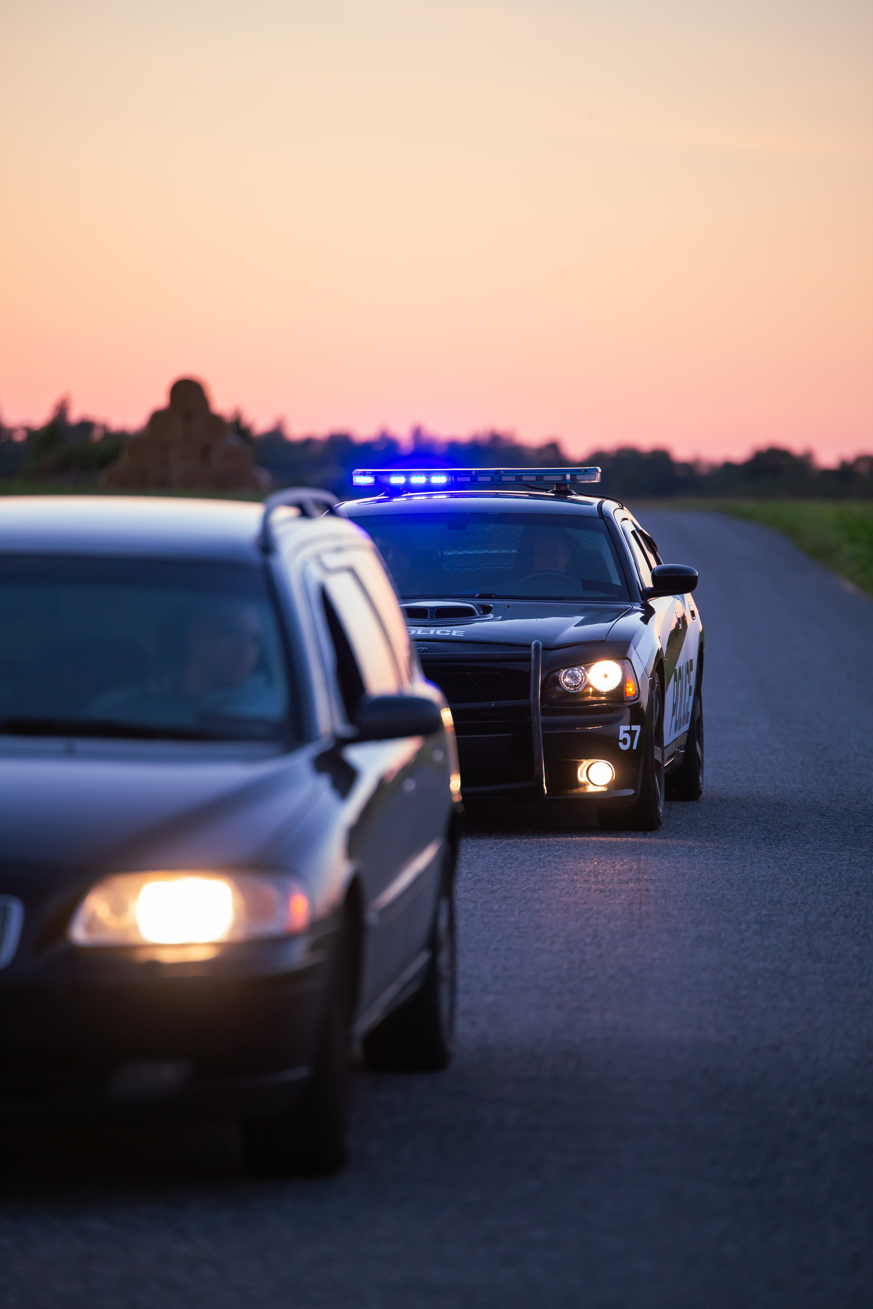 A police car pulling over a driver - if you need the help of a Palm Beach County DUI lawyer after a police encounter, contact Peterford Law today!